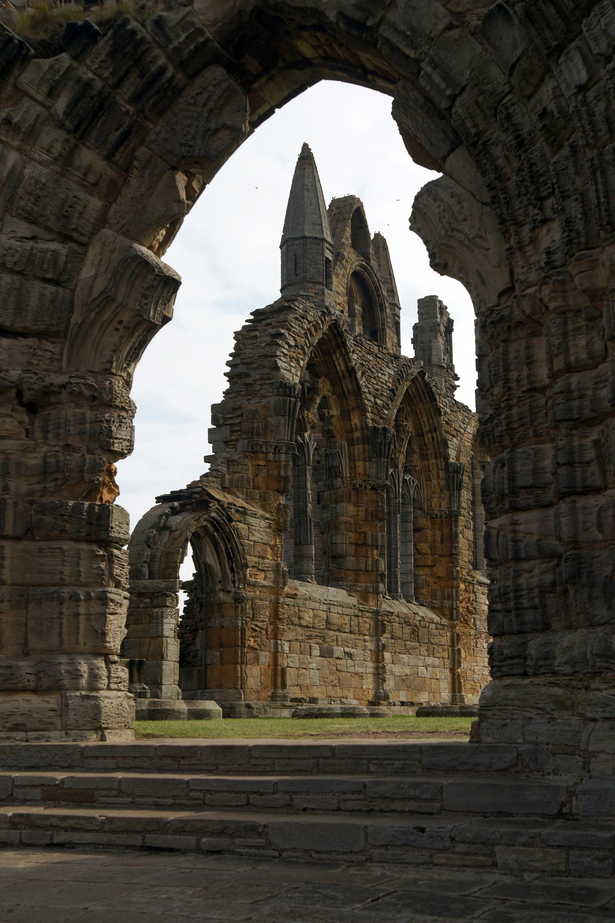 Whitby Abbey ruins framed by stone arch on the clifftop above Whitby, North Yorkshire